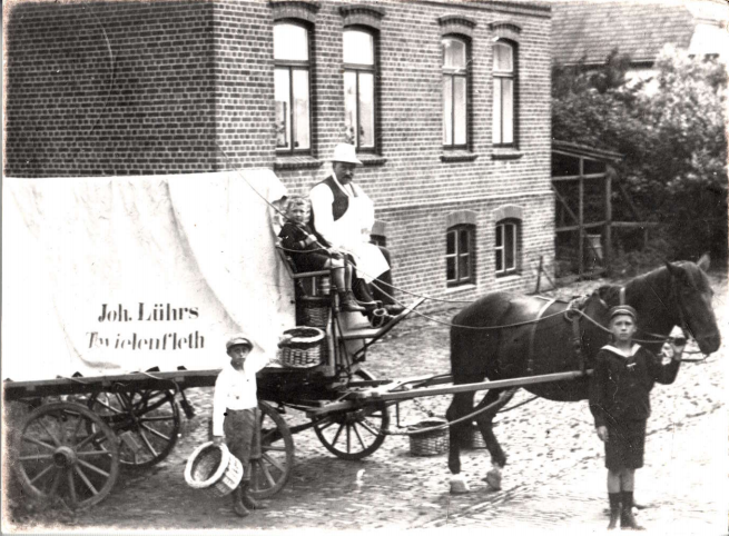 Firmengründer Johann Lührs auf dem Kutschbock. Sein Sohn Hans hält das Pferd